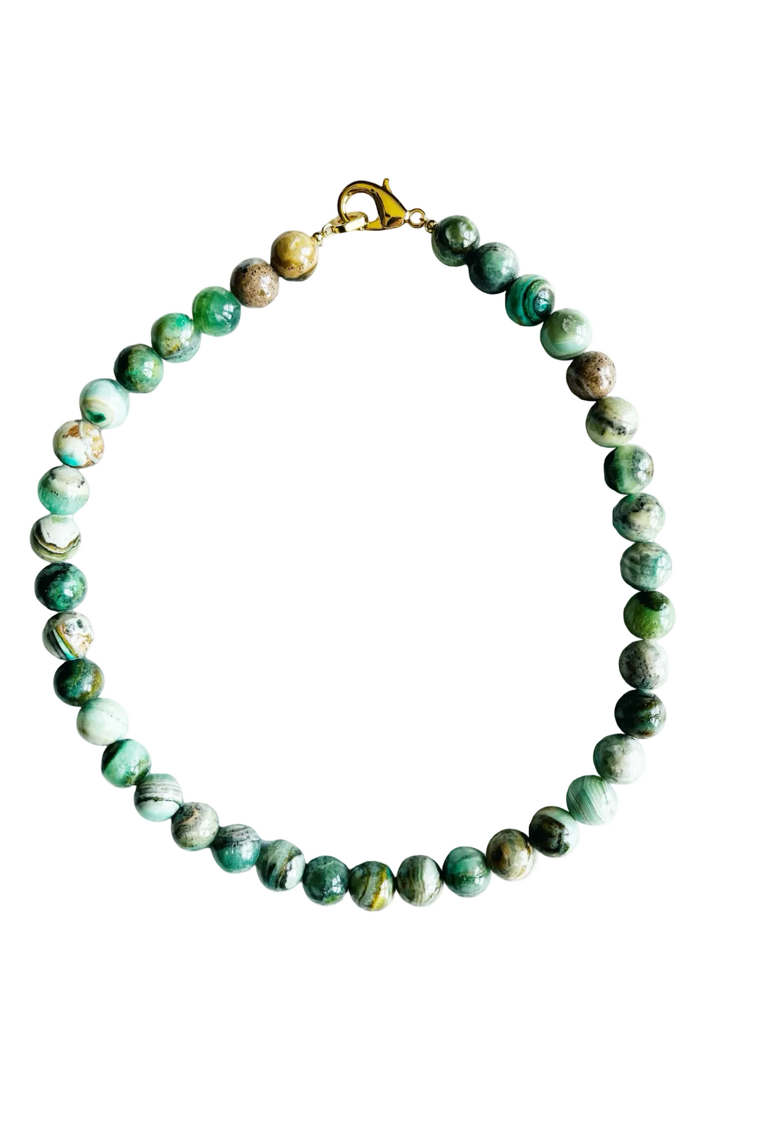 A beaded necklace made of polished round green stone beads with natural marbling and some brownish inclusions, finished with a gold-tone lobster clasp, shown on a plain white background.