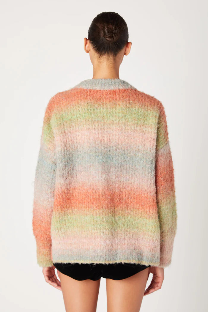 Person wearing a multicolored striped sweater on a white background