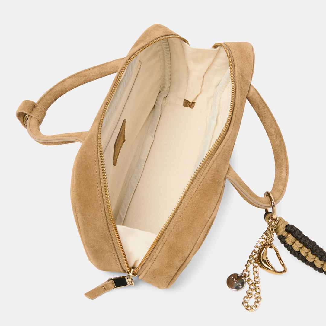 Beige handbag with a strap and decorative charm 