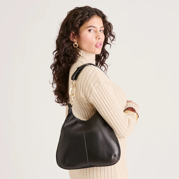 Woman wearing a black leather handbag over her shoulder