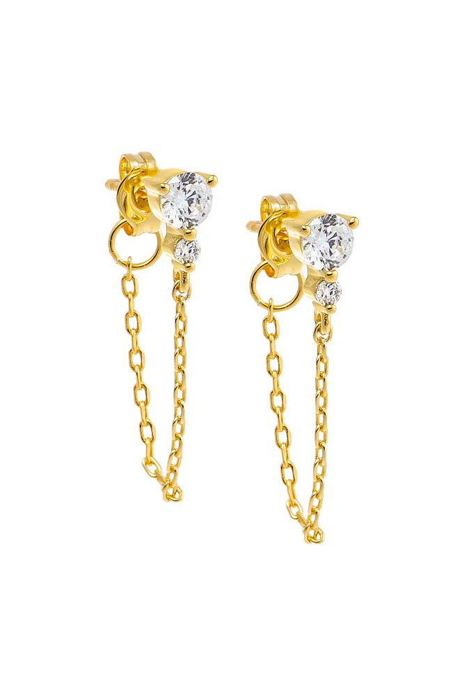 Gold earrings with clear gemstones and gold chains on a white background