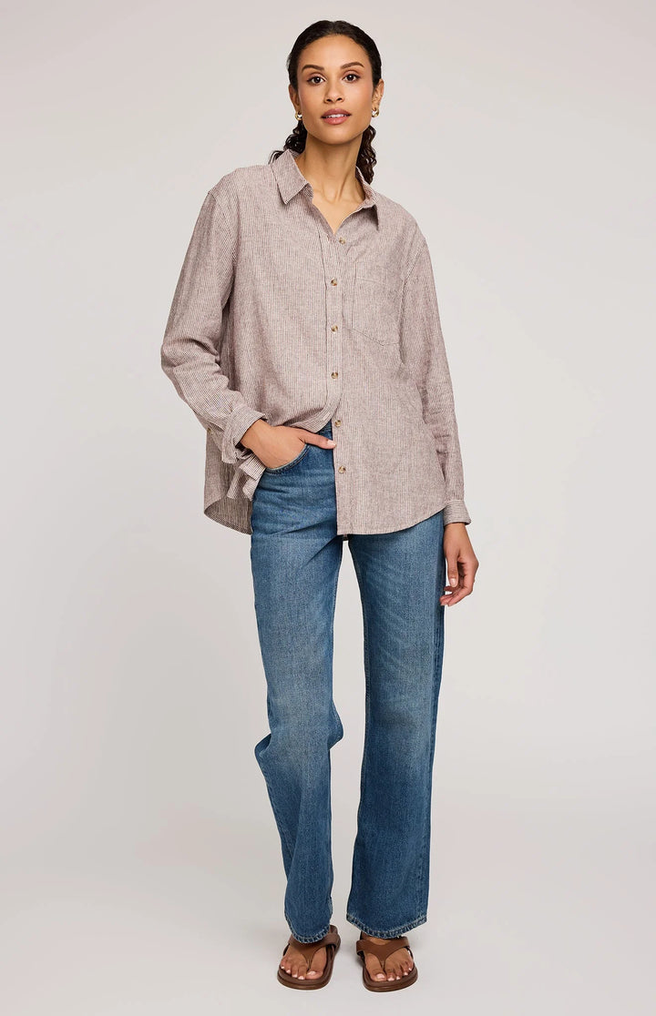 Woman wearing a beige checkered shirt and blue jeans on a white background