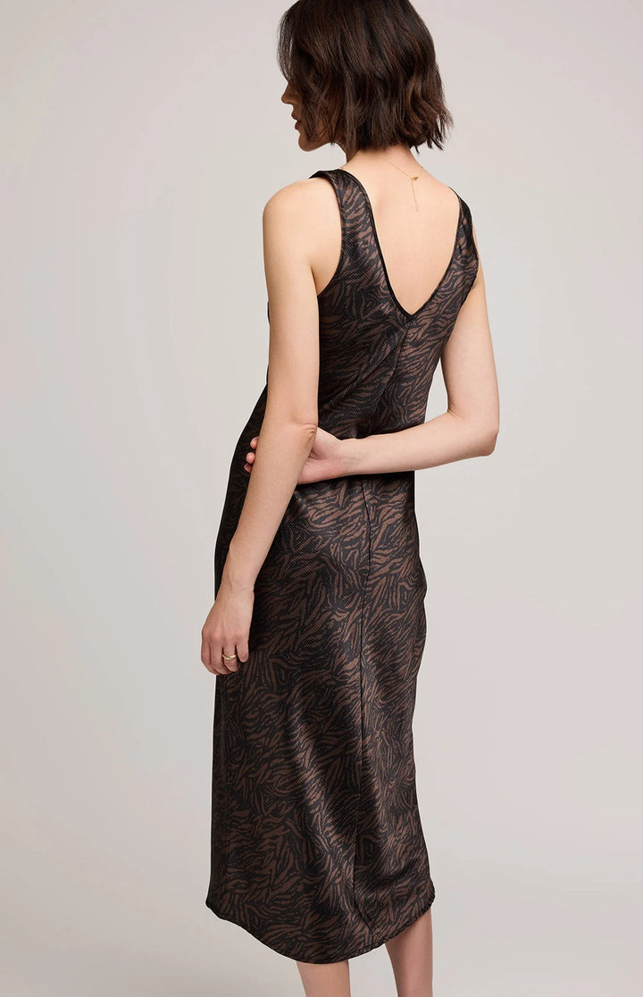 Woman wearing a black patterned dress against a plain background