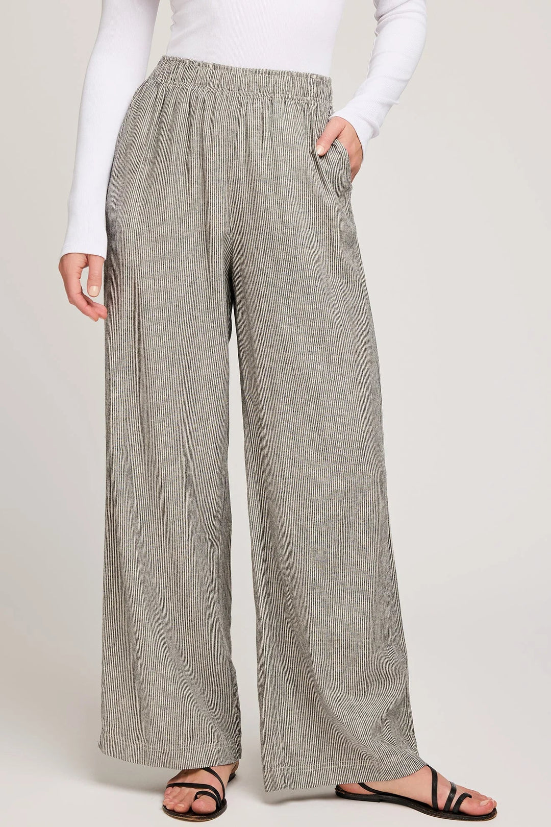 Person wearing gray checkered pants on a plain background