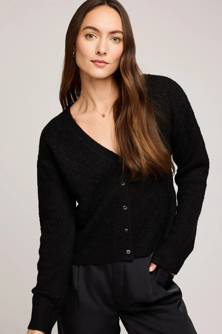 Woman wearing a black cardigan against a plain background