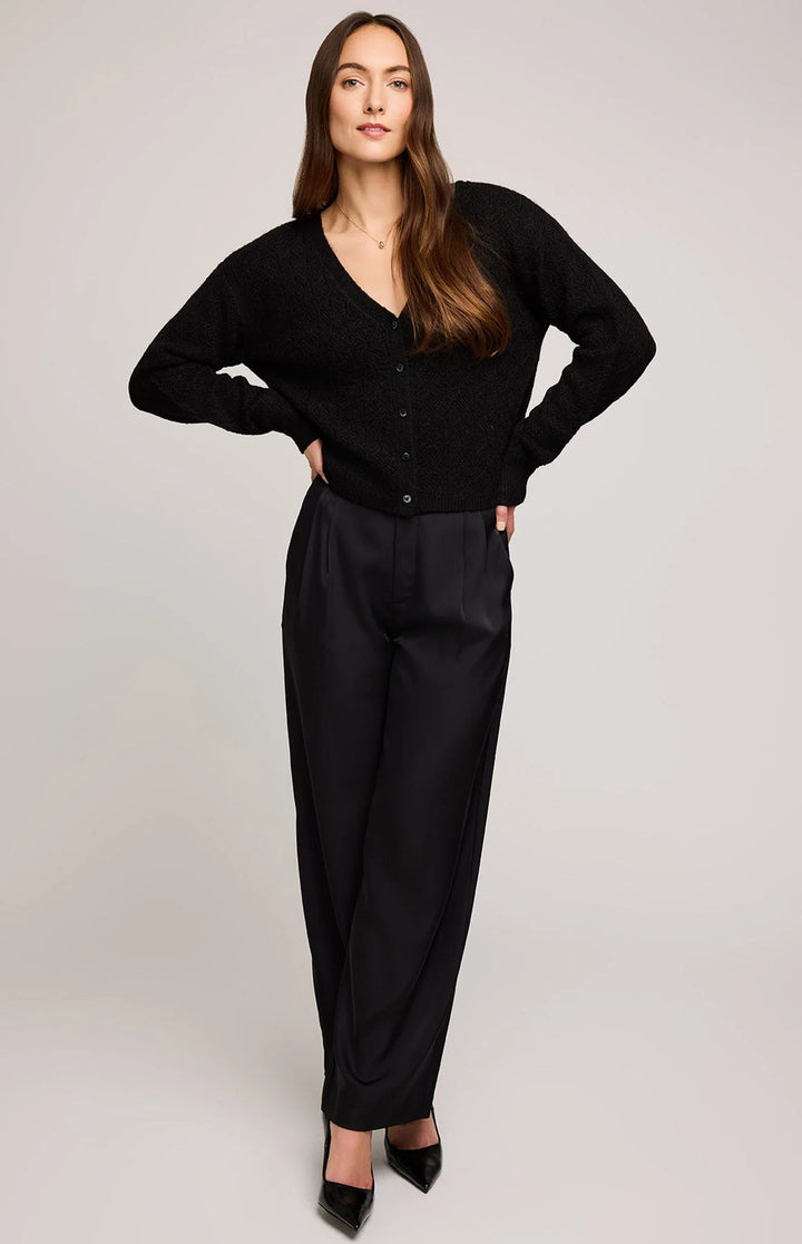 Woman wearing a black cardigan and black pants on a white background