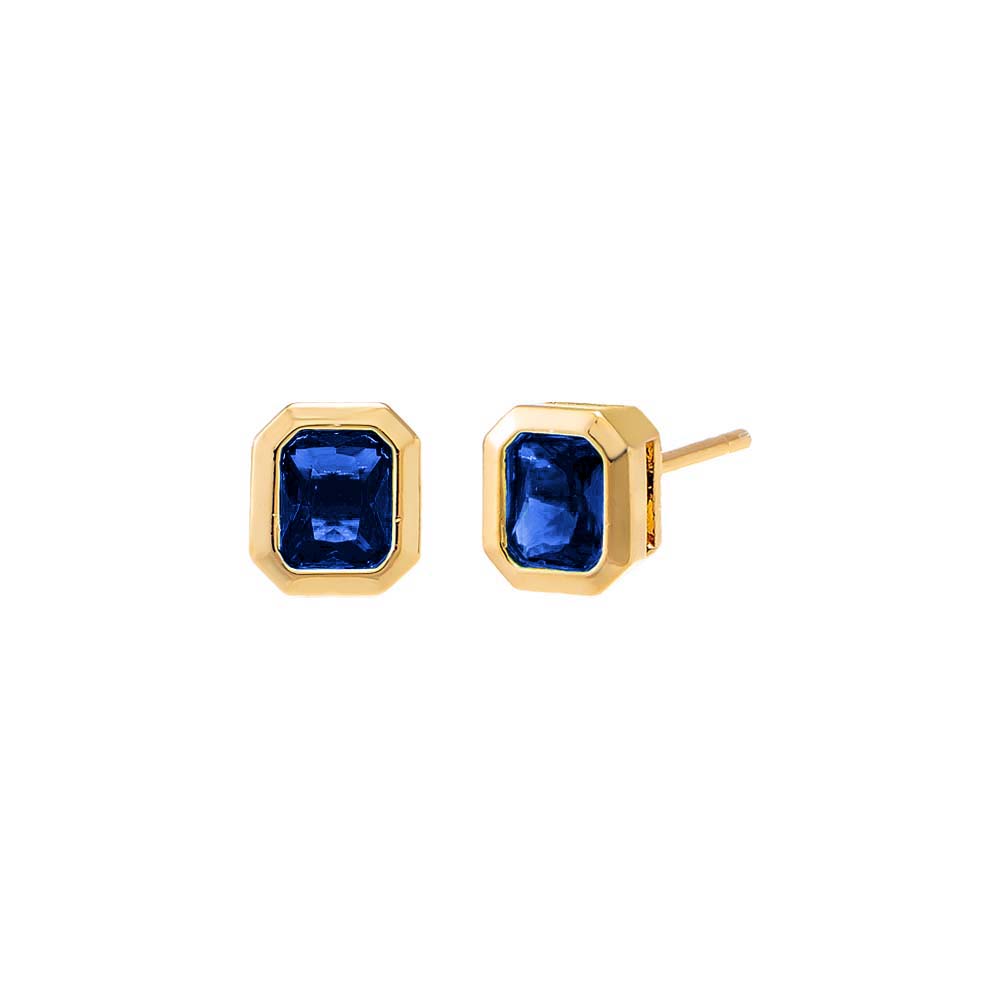 Gold earrings with blue gemstones on a white background