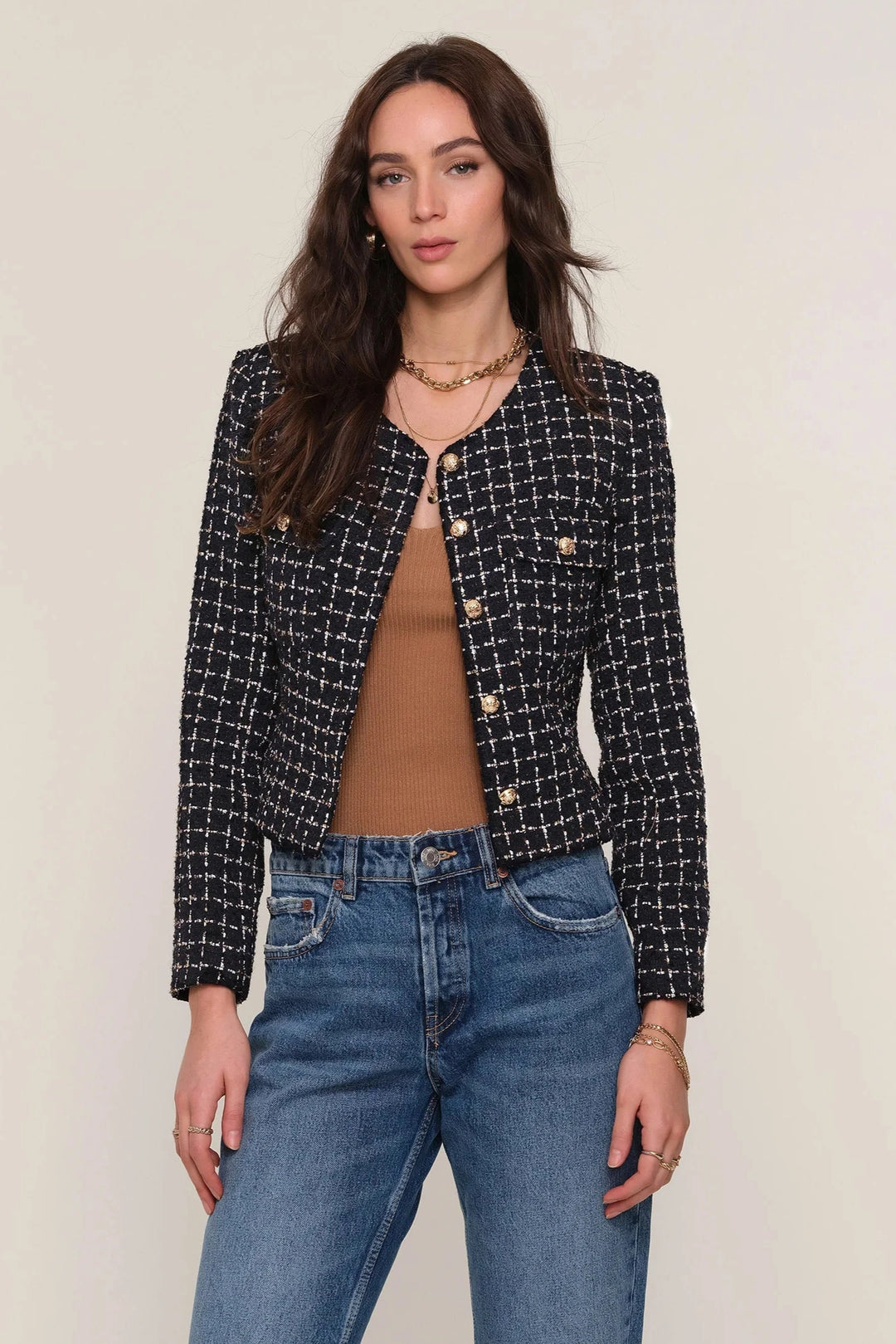 Woman wearing a black and white patterned cropped blazer