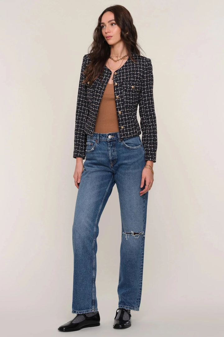 Woman wearing a black and white patterned cropped blazer