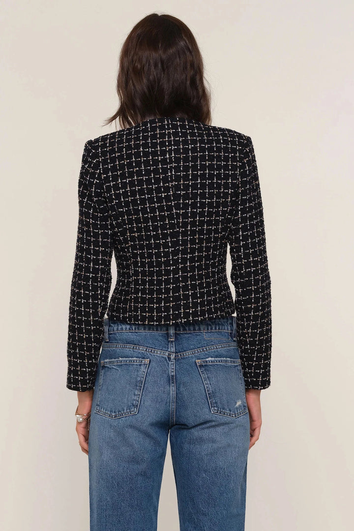 Woman wearing a black and white patterned cropped blazer