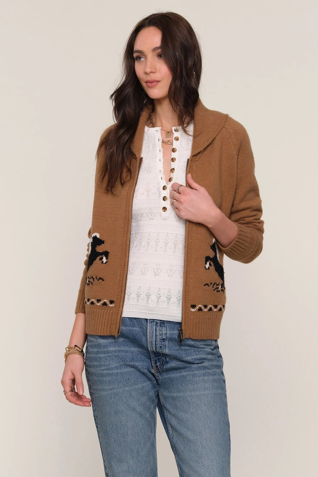 Woman wearing a brown cardigan with black animal patterns on a plain background