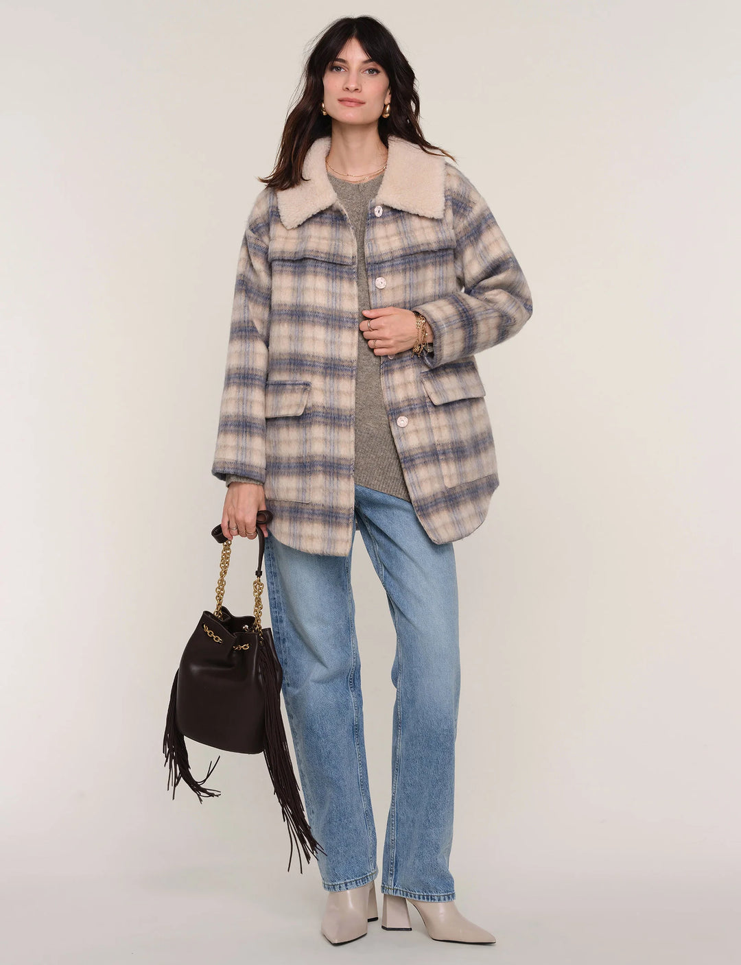 Woman wearing a plaid coat with a white background