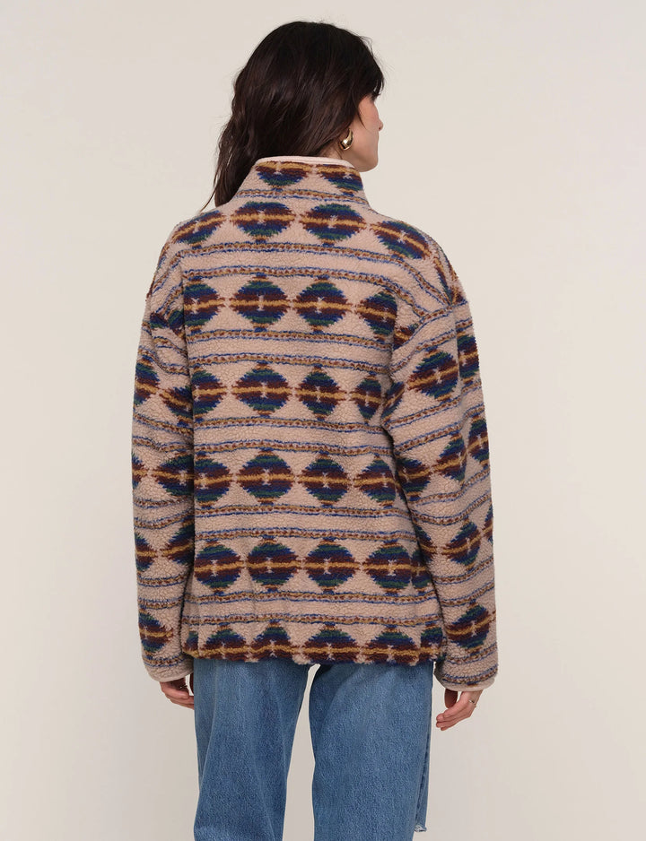 Person wearing a patterned jacket with a plain background