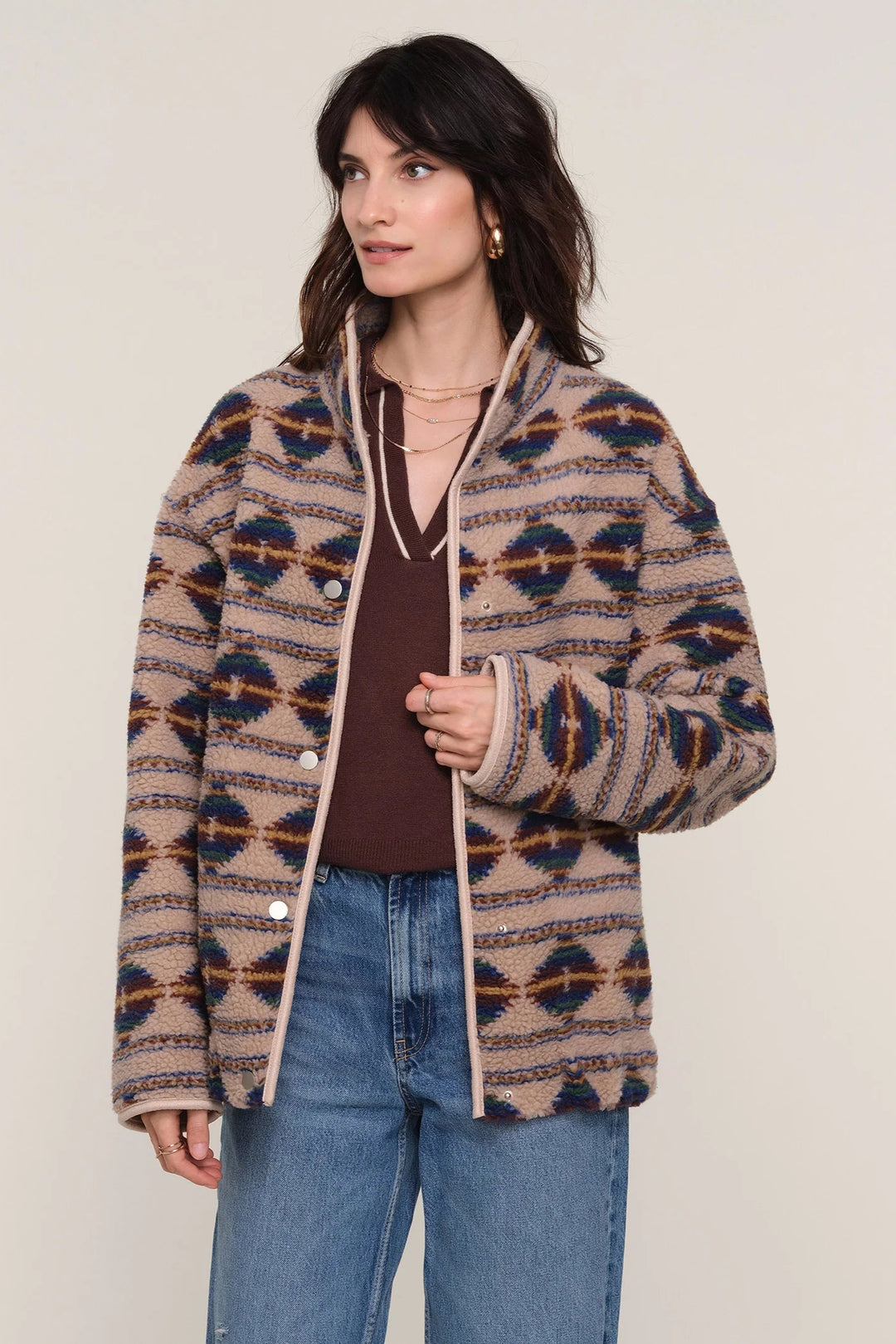Woman wearing a patterned jacket with a plain background