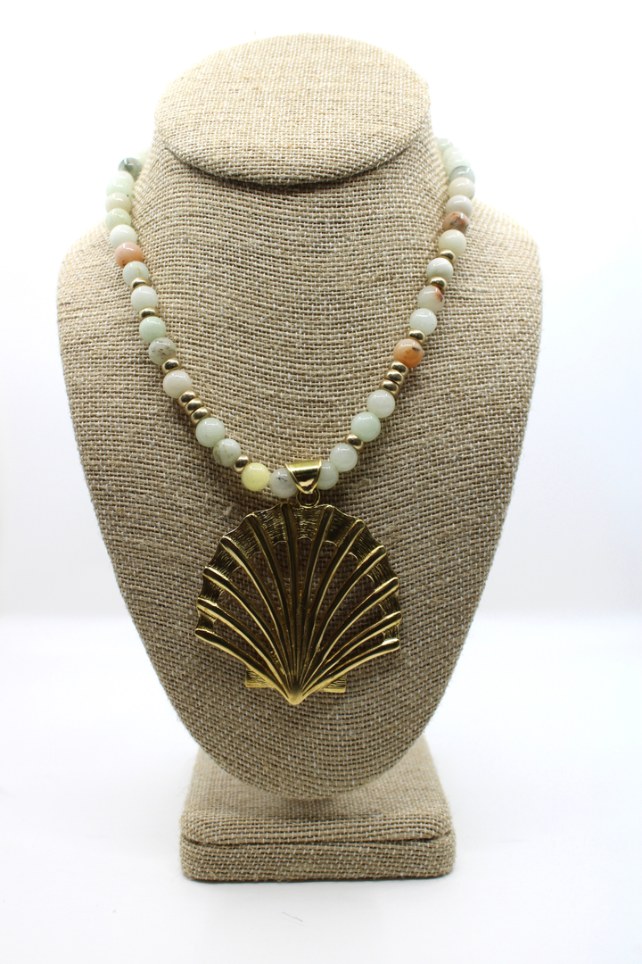 Necklace with a shell pendant on a beige bust against a white background