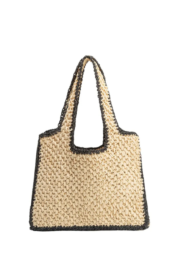 Woven handbag with black trim on a white background