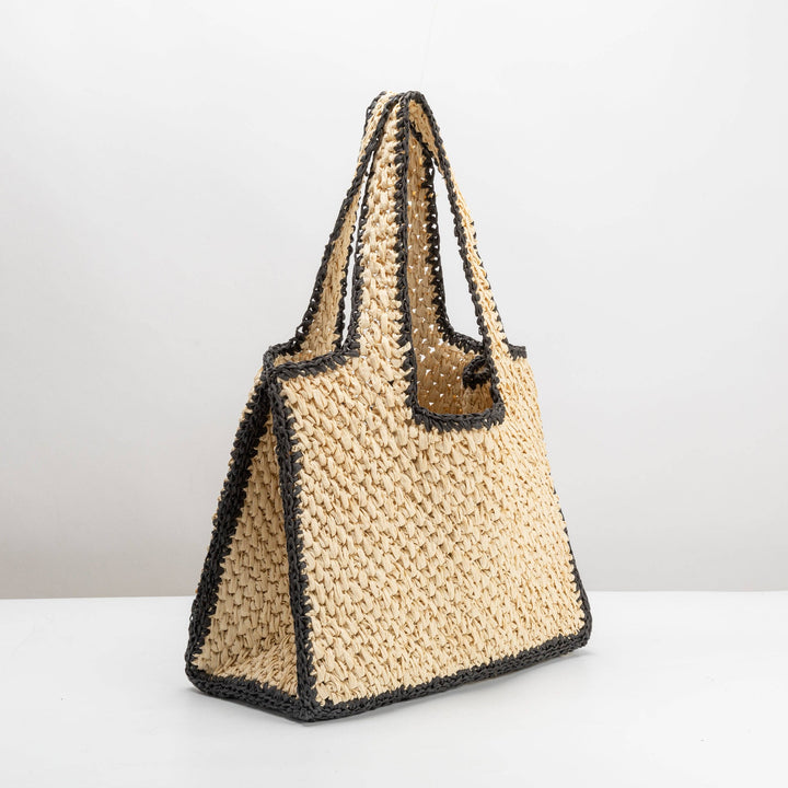 Woven handbag with black accents on a white background