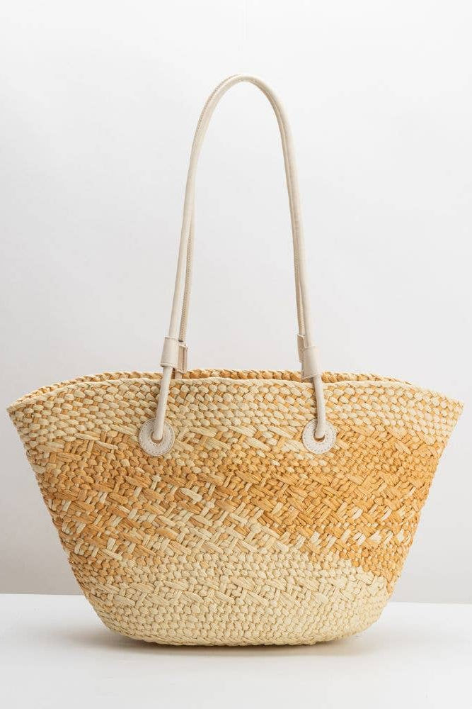 Woven straw bag with beige handle on a white background