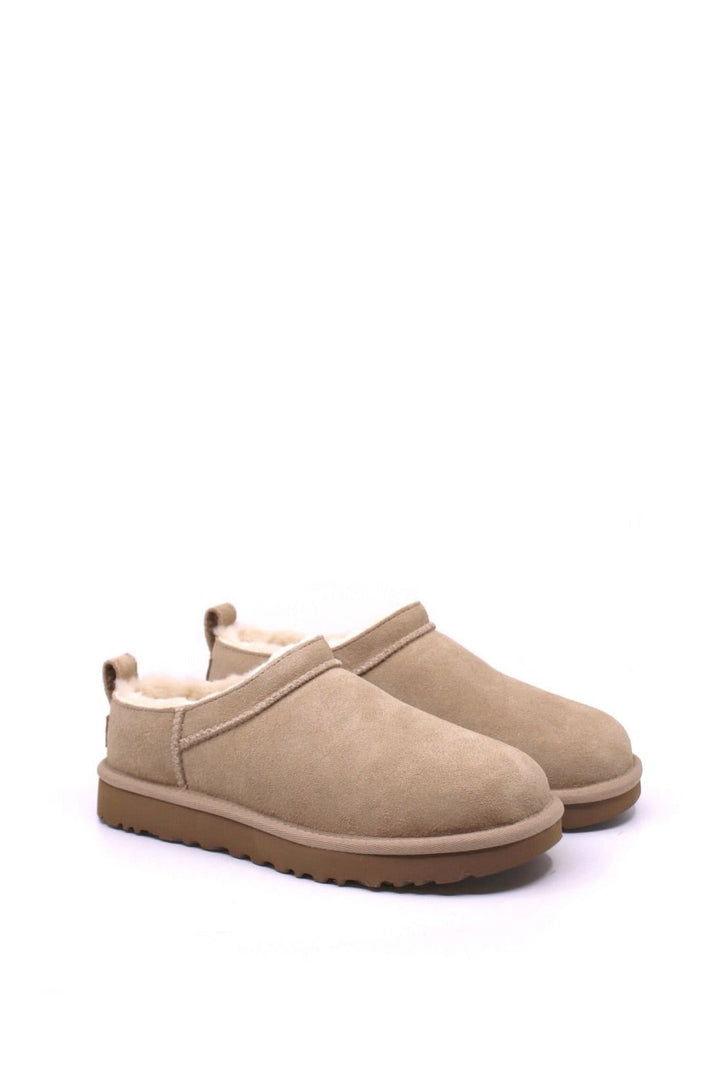 Pair of beige slip on boots by UGG 