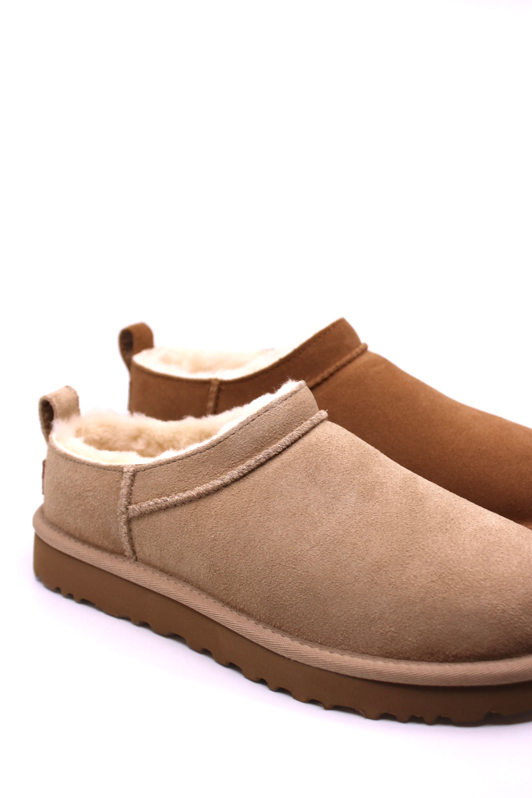Pair of brown and beige slip-on boots with fur lining by UGG