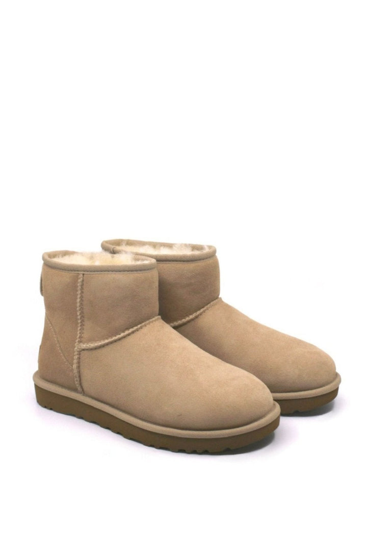 A pair of UGG Classic Mini II boots in color sand, featuring a low heel and a round toe.