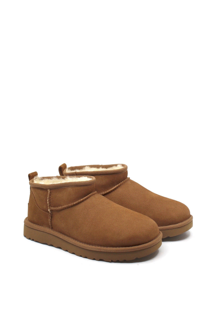 A pair of chestnut colored UGG Classic Ultra Mini boots with a low shaft height, featuring sheepskin lining and a lightweight sole.