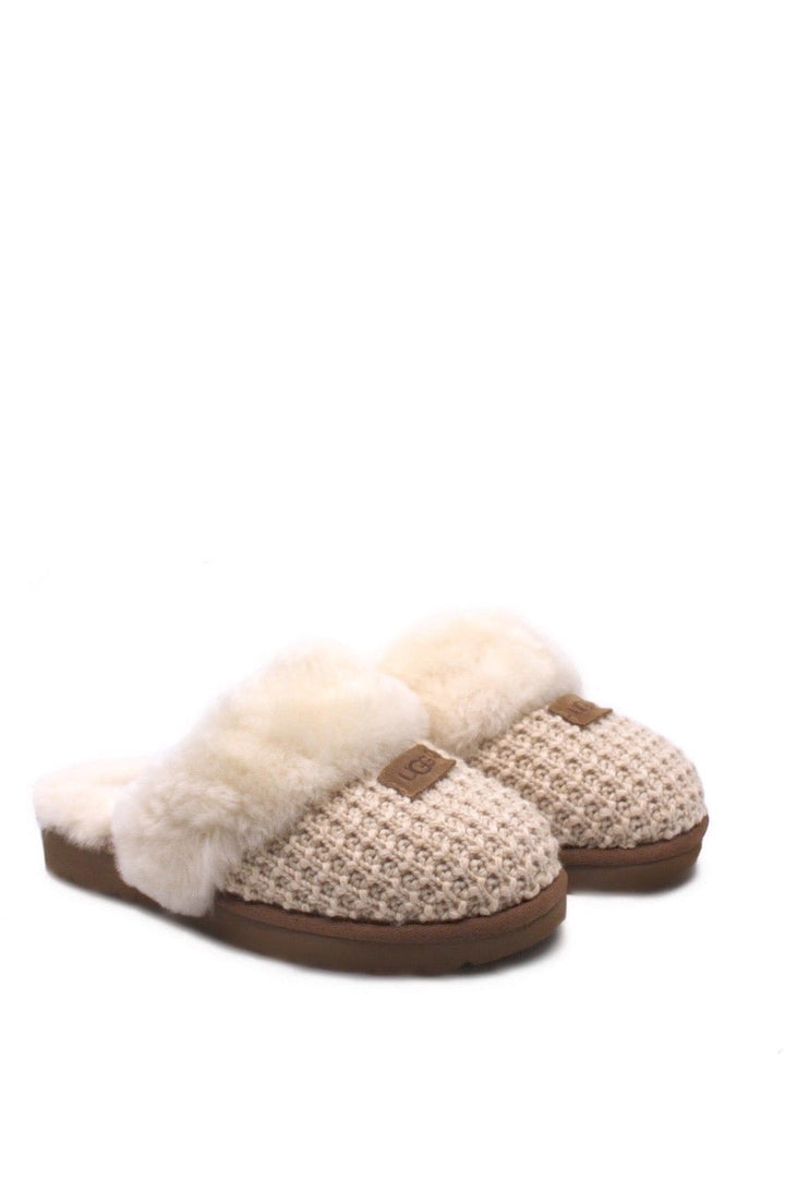 A pair of beige UGG Cozy Cream slippers with a sheepskin lining and a fluffy collar.