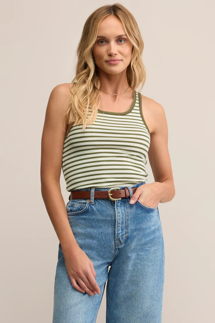 Woman wearing a striped tank top and jeans on a beige background