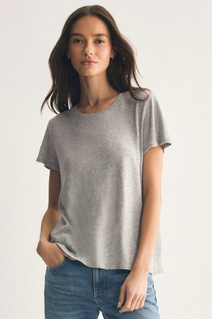 Woman wearing a gray t-shirt and blue jeans on a white background