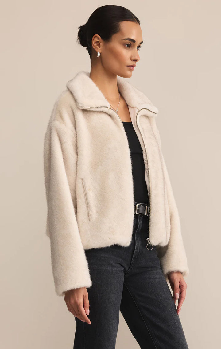 Woman wearing a cream-colored jacket against a beige background