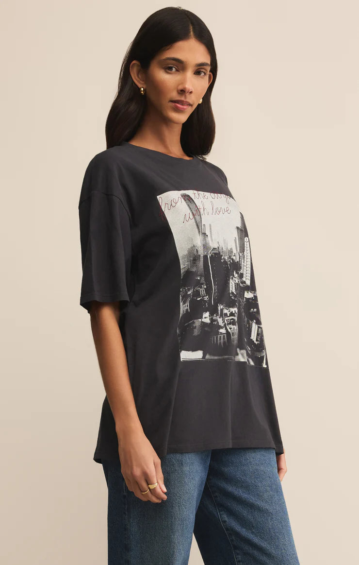 Woman wearing a black t-shirt with a graphic design on a beige background