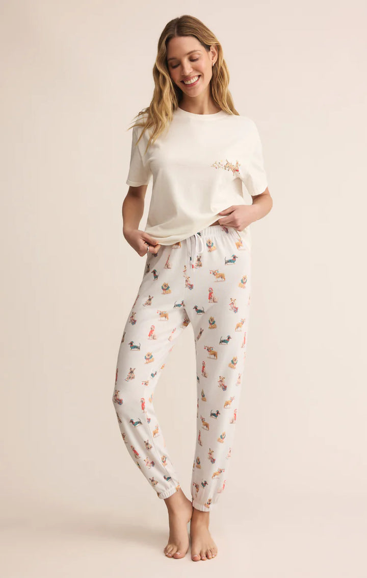 Woman wearing a white t-shirt and pajama pants with dog winter print