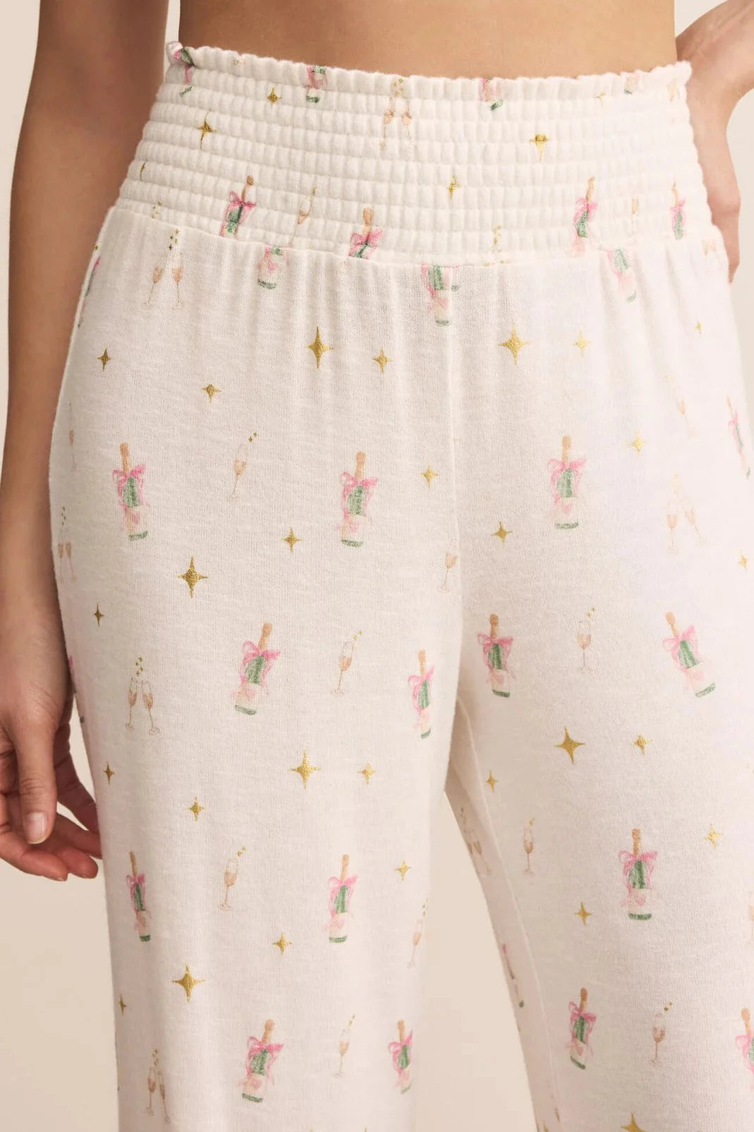 White pants with a subtle pattern of small figures and stars on a neutral background