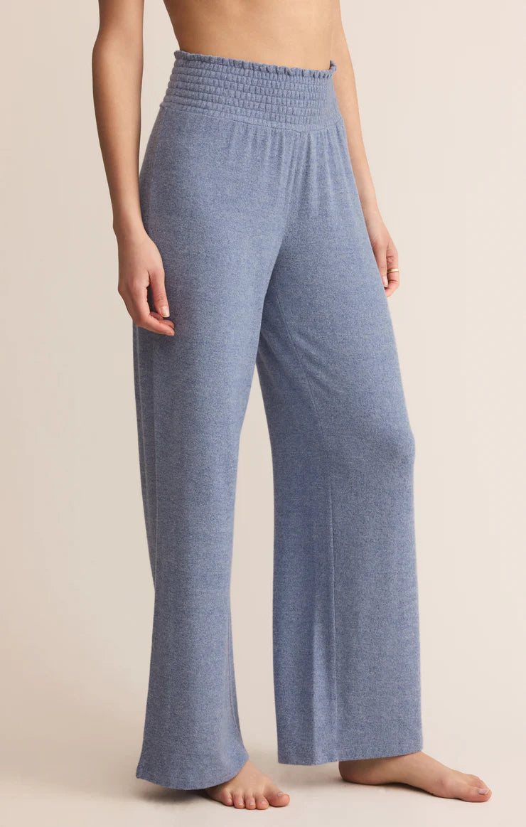 Blue lounge pants worn by a person on a beige background