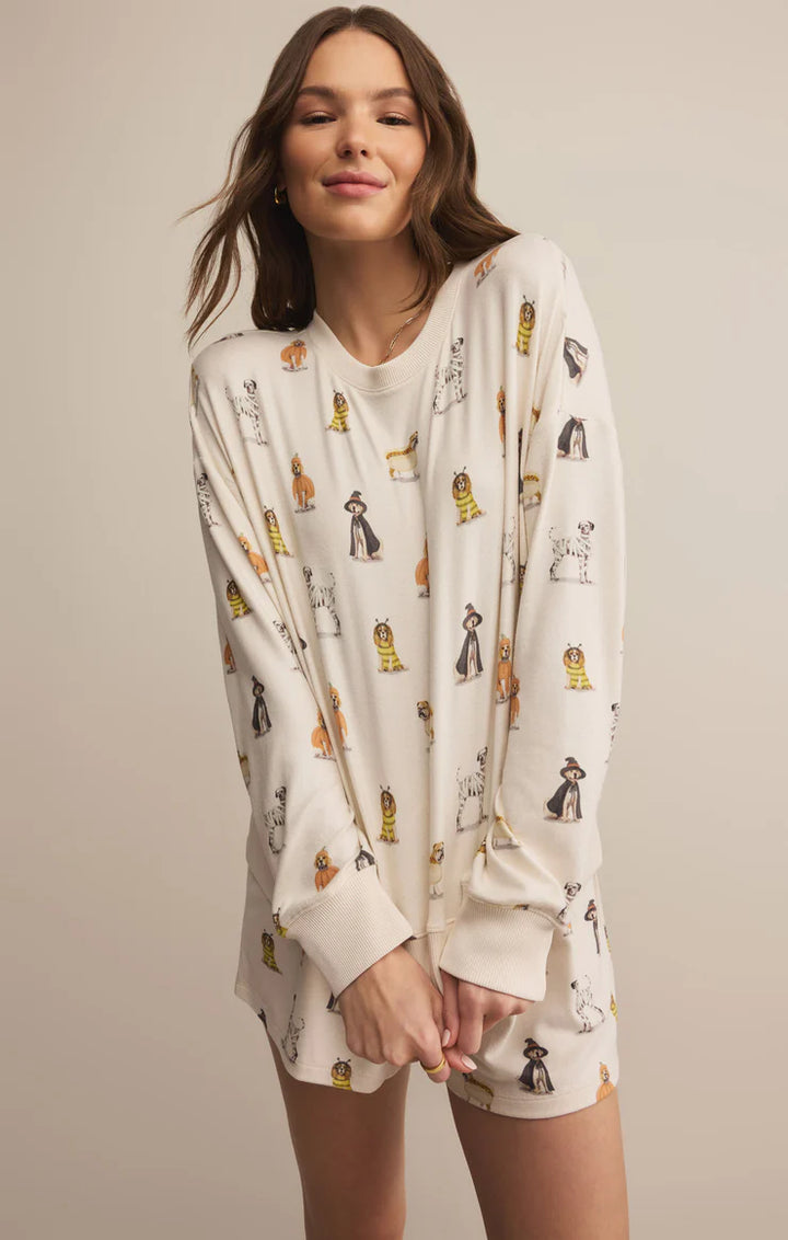 Woman wearing a long-sleeve shirt with cat pattern on a plain background