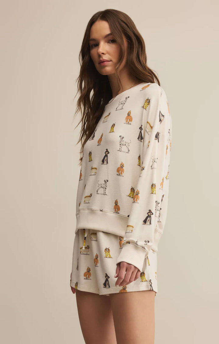 Woman wearing a cream-colored pajama set with animal prints on a beige background