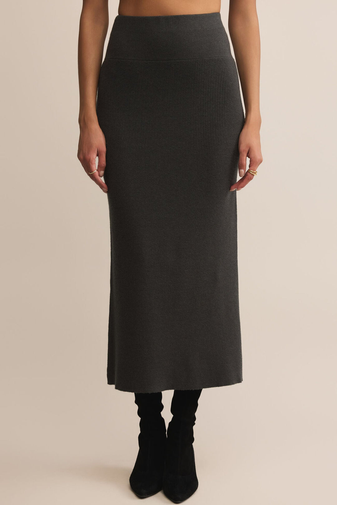 Person wearing a black skirt on a beige background