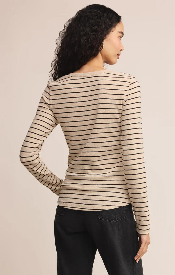 Woman wearing a striped sweater against a beige background