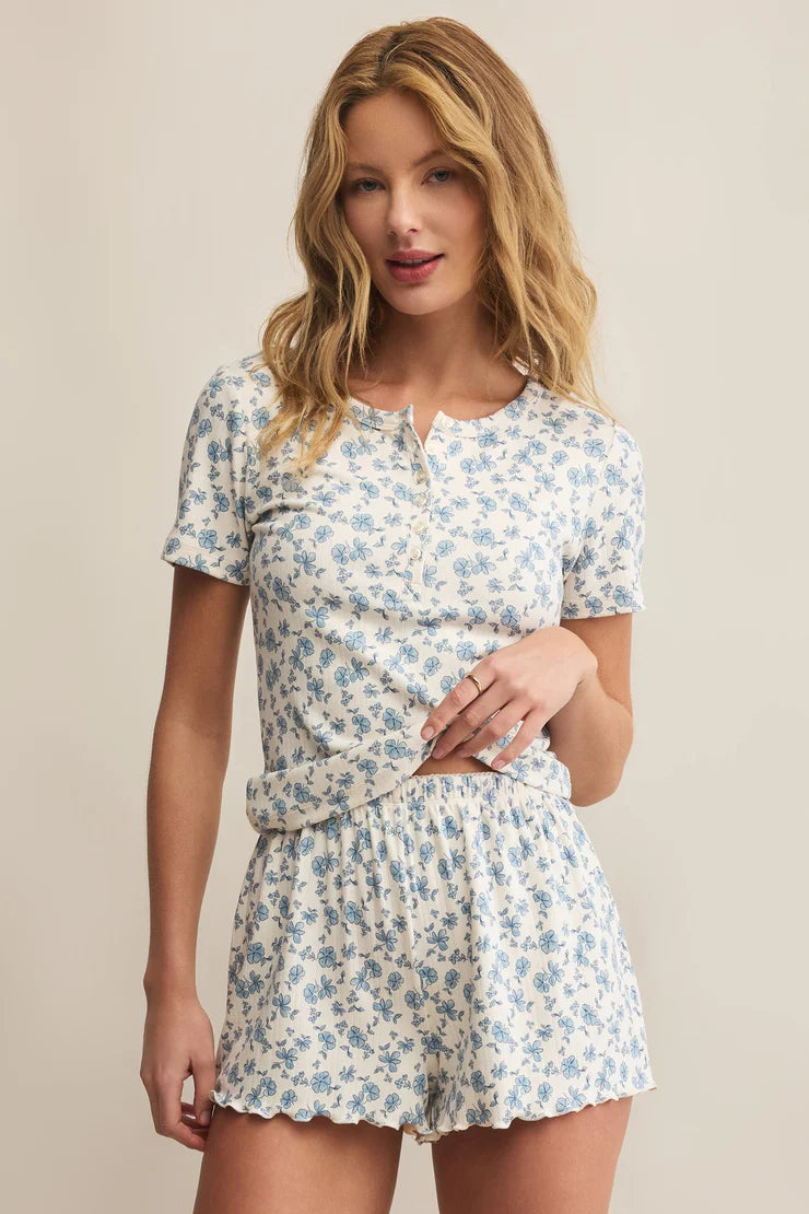 Woman wearing a matching floral lounge set against a beige background