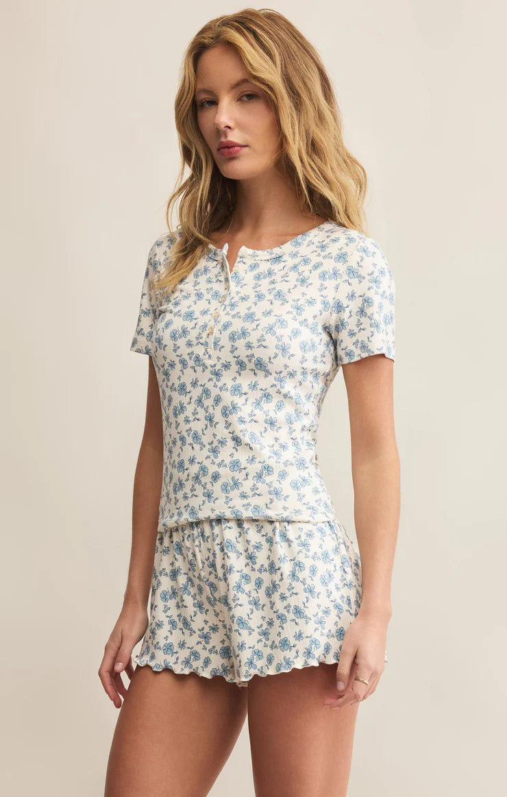 Woman wearing a floral pajama set against a beige background