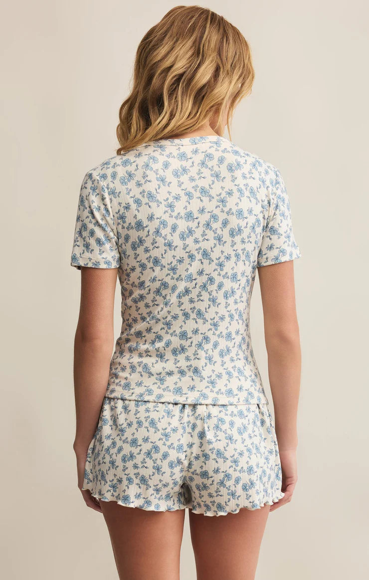 Woman wearing a floral pajama set against a beige background