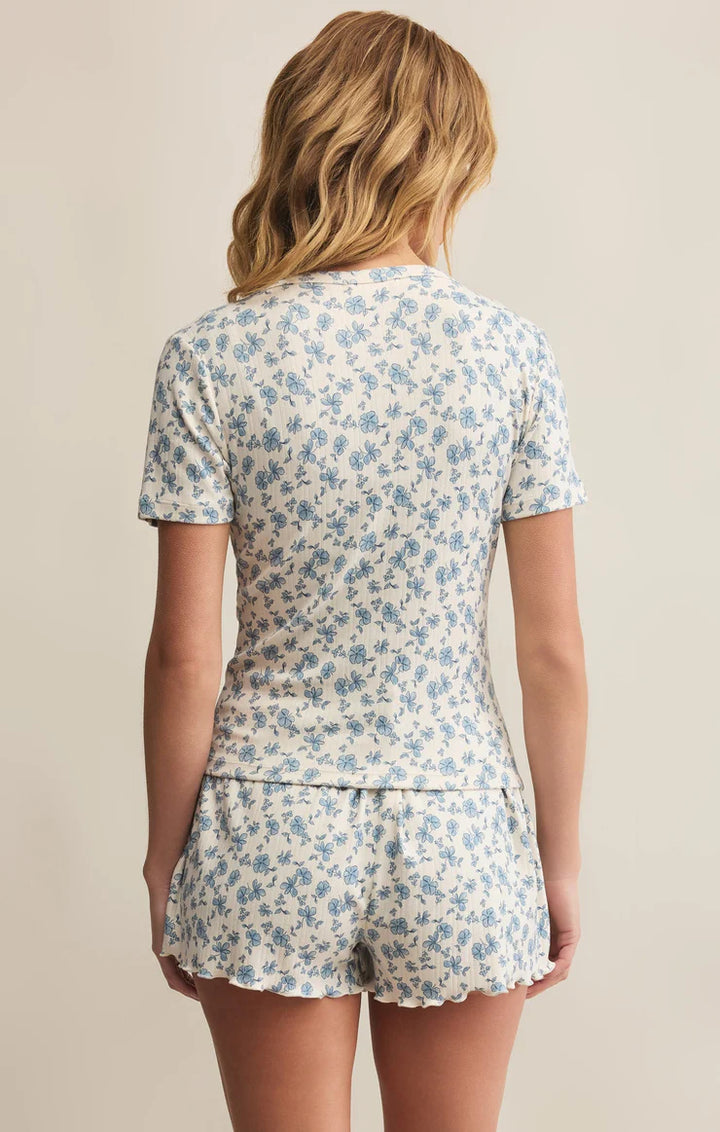 Woman wearing a floral pajama set against a beige background