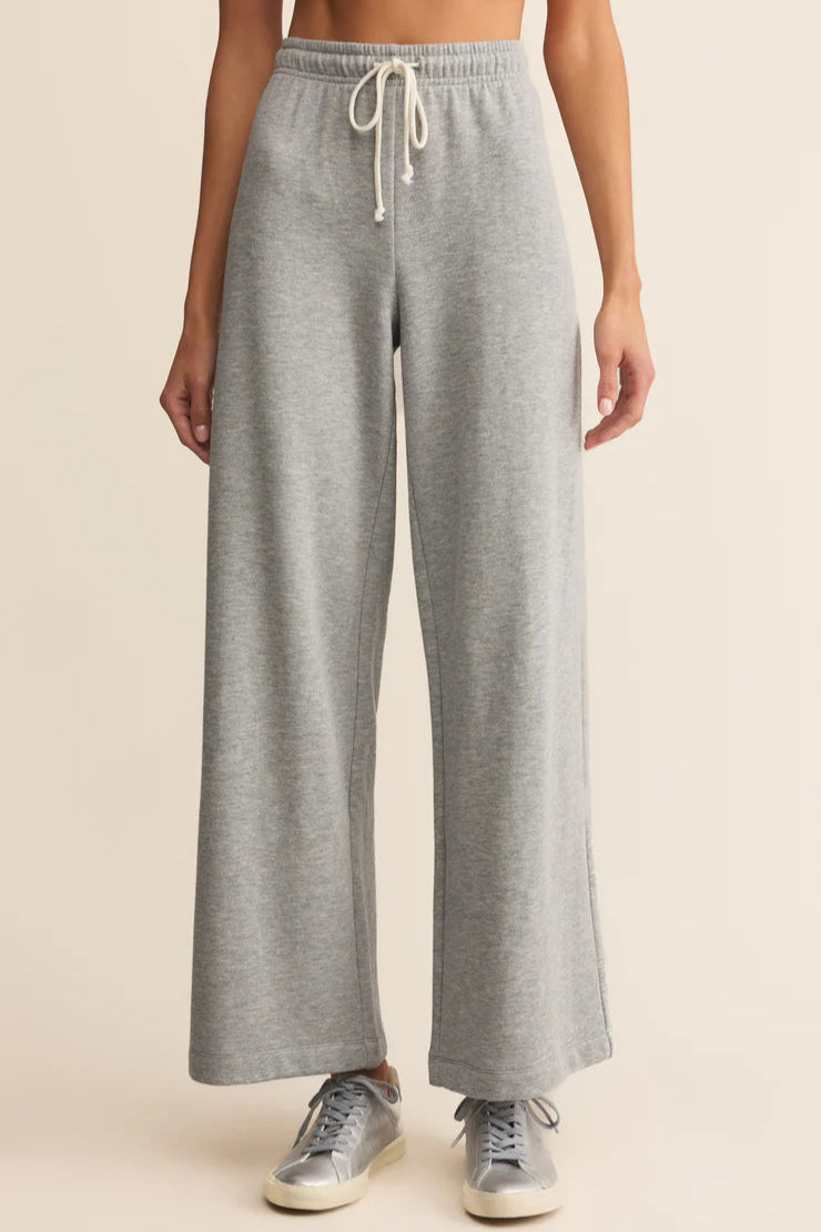 Gray sweatpants worn by a person on a beige background
