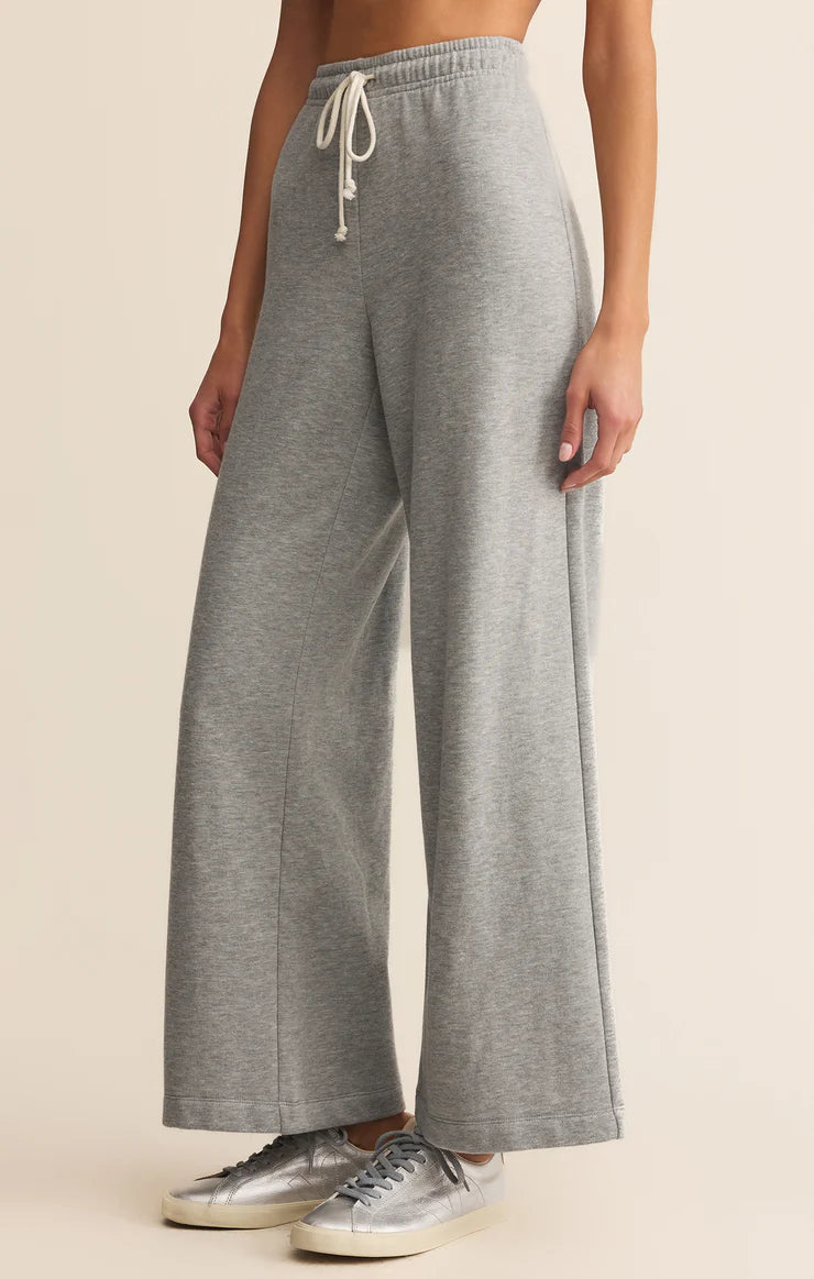 Person wearing gray wide-leg pants with a beige background