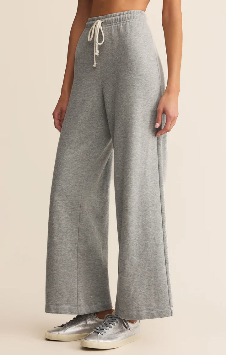 Person wearing gray wide-leg pants with a beige background