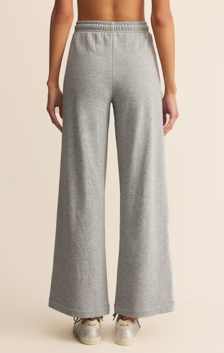 Gray wide-leg pants worn by a person on a beige background