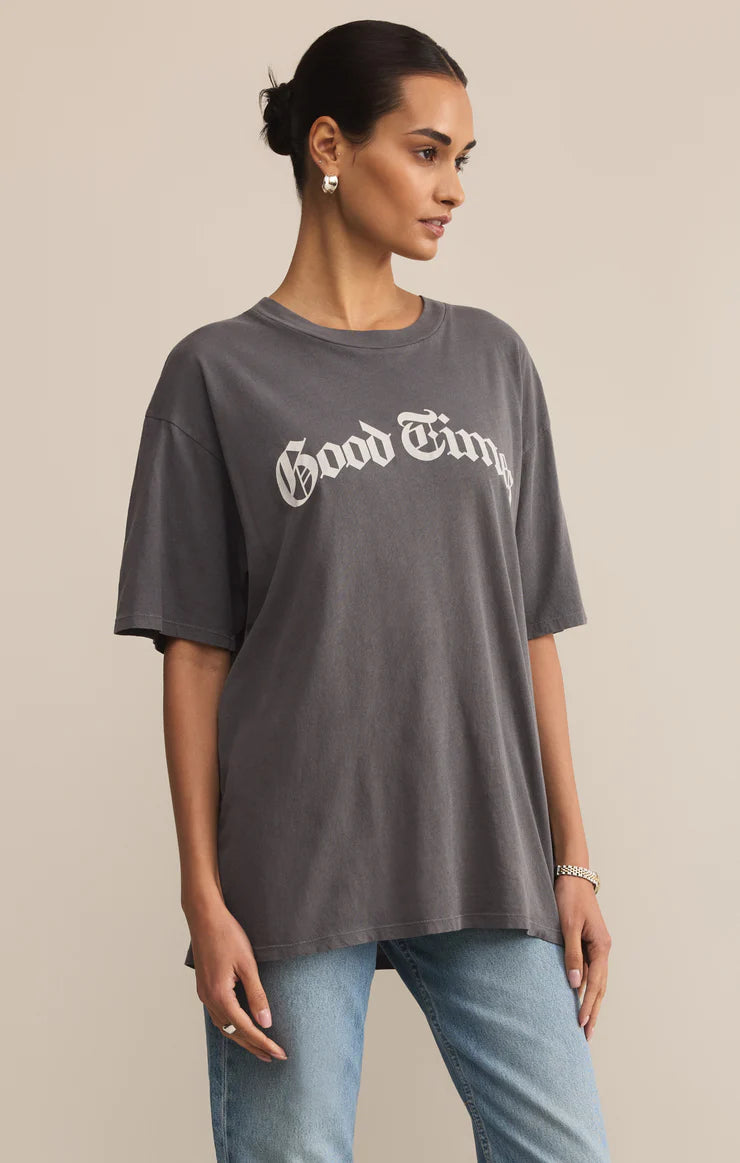 Woman wearing a gray 'Good Times' t-shirt against a beige background