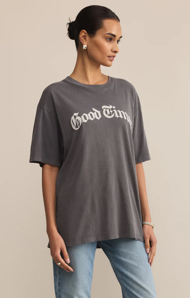 Woman wearing a gray 'Good Times' t-shirt against a beige background