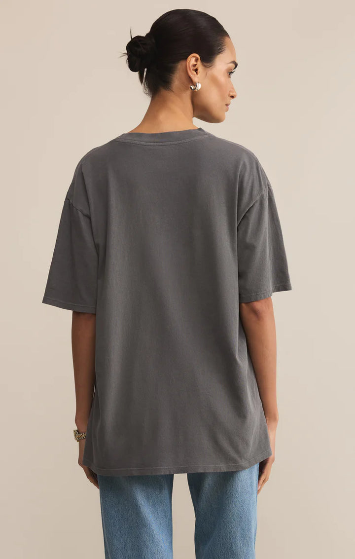 Person wearing a gray t-shirt and blue jeans on a beige background