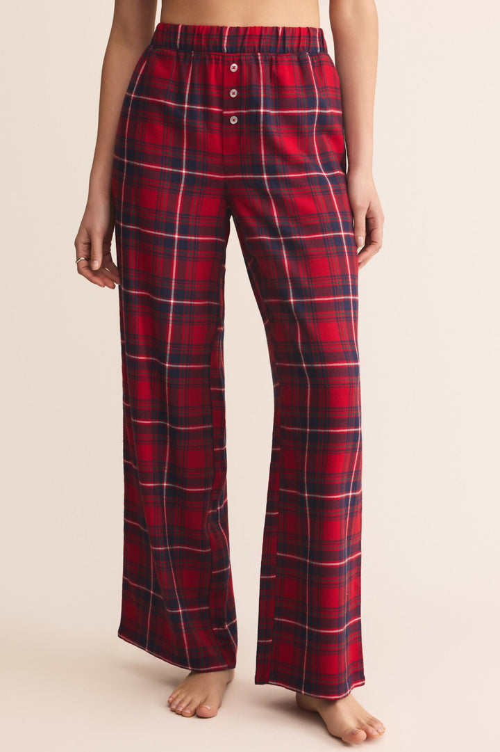 Red plaid pajama pants worn by a person on a beige background